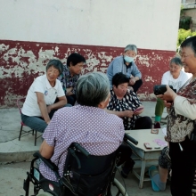 A group of middle-aged Chinese women talk to each other.