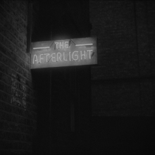 A grainy image displaying a neon sign reading “The Afterlight”.