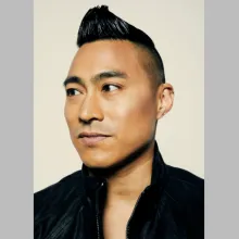 Headshot of a Filipino-American man with an undercut looking seriously into the distance.