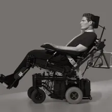 black and white image of a white man in a power chair taken in profile