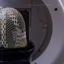 Person in MRI with netting over their face.