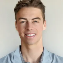 Reed Martin. A man with white skin smiles at the camera. He has short, brown hair, blue eyes and is wearing a blue collared shirt.