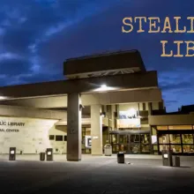 Nighttime exterior shot of a library building, the text "Stealing a Library" in the upper right corner