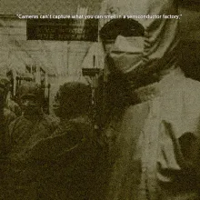 A person in safety gear and a mask looks at the camera, standing next to the door to a room where more people in the same gear are pictured inside.