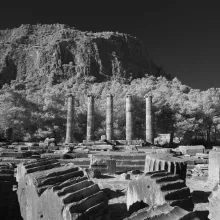 A mountain rises in the distance of ruins.