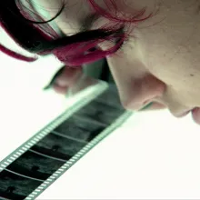 A young woman examines a black and white negative on a light table.