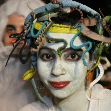 Participant in Greenwich Village Halloween Parade with white face paint and snakes in her hair.