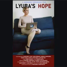Film poster showing a blonde woman sitting on a couch with an ankle monitor on, holding a laptop.
