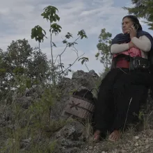  Mariano´s mother in her traditional clothes from Chamula and surrounded by the mountains of his home town calls him by cellphone. 