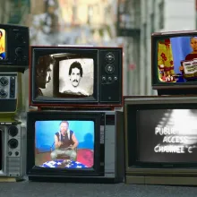 Various vintage television sets made to look like they're laying on the ground on a New York City street show scenes from public access Tv shows