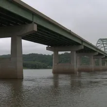 A shot of a bridge over a river taken from below on a grey cloudy day