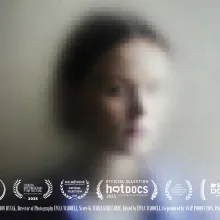 A photo portrait of the film's protagonist - a young Ukrainian woman with short, chin length hair - but the image is heavily pixelated/distorted.