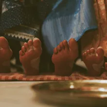The right foot of five different girls and women with toes pointing upward to reveal the soles of their feet, which have been dyed red.