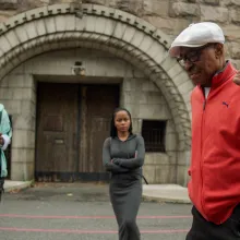 Experiment Survivor Herbert Rice stands in front of Holmesburg Prison with his grandchildren