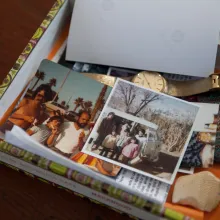 Cigar Box with family photos, a gold watch, turquoise inlaid belt buckle, white buffalo carving.