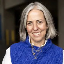 Headshot of Jennifer Sofio Hall. Fair skinned woman with a blue sweater and white shirt. Shoulder length hair and a wide smile.