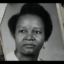 A black-and-white photo of Colette, an African woman with hair parted to one side, flanked by black-and-white photos of African families. From Alain Kassanda’s ‘Colette et Justin.’ Courtesy of IDFA