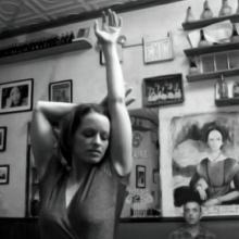 A woman from Matthew Diamond's 'Dancemaker' poses with her arm extended towards the ceiling.
