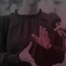 A picture of a person with light skin from chin down moving their hands. Another light skinned hand holding a microphone is facing this person.