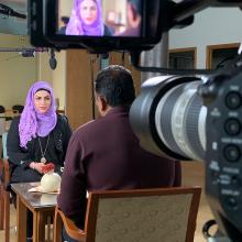 A BTS photo of a female participant, wearing a purple headscarf, being filmed for 'Healing the Healers.' Courtesy of Transform Films.