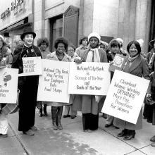 A black and white photo of several women holding signs at a protest. A still from '9to5: The Story of A Movement'. Courtesy of Steve Cagan
