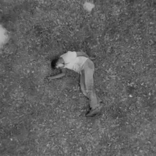 Ambroise Ruzidana as Joe in Ibrahim Shaddad’s ‘Hunting Party.’ He is wearing a t-shirt and trousers, and is lying on the ground. Courtesy of Flaherty Seminar.