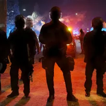 A line of uniformed policemen silhouetted against streetlights. From Mike Shum’s ‘Police on Trial.’ Courtesy of FRONTLINE (PBS). 