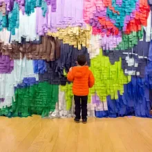 A child stands in front of artist Aves Aras’ multi-colored art installation made of paper and glue. From Craig and Brent Renaud’s ‘State of the Art.’ Photo by Thomas Willis. Courtesy of PBS.