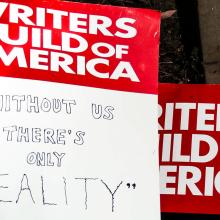 A collection of signs that state “Writers Guild of America: Without Us, There’s Only Reality.” Courtesy of Shutterstock