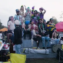 Black and white costumed New Orleanians celebrate Mardi Gras on the pedestal of a now absent confederate monument. From CJ Hunt and Darcy McKinnon’s The Neutral Ground. Photo by Paavo Hanninen. Courtesy of POV.