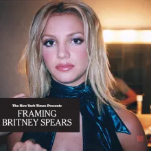Britney Spears is looking at the camera in a dressing room, wearing a sparkling blue halter top