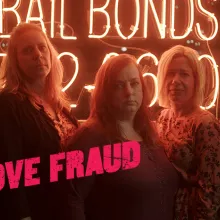 A group of middle-aged women standing in front of a bail bonds neon sign