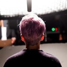 The back of a woman with pink hair's head.