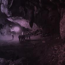 Several people inside a dark cave.