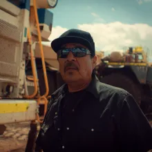 Indigenous coal miner poses for photo in front of plant equiptment