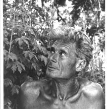 Black and white portrait of Alan Chadwick in front of a plant.