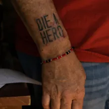 A picutre of a person's arm with 'Die a Hero' tattooed on it.