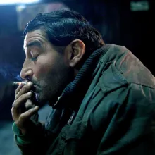 A man smokes in a darkened screening room