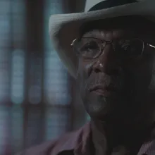 African-American man with a hat staring into the camera