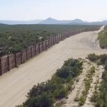 The US-Mexico border, patrolled by the green Border Patrol SUVs