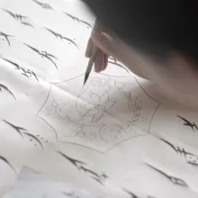 Hu xin writes Nushu characters with a small paint brush. 