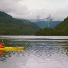 yellow kayak glides across large lake