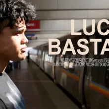 A young boy stands before an arriving subway train.