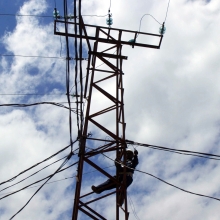 line worker works on electric tower in the Congo