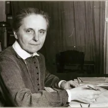 Sister Margaret Slachta is sitting in front of her desk that is covered with letters.