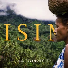 An indigenous woman of Papua New Guinea walks before the rain forest with a basket on her head. 