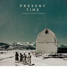 four monks walk outside of a white monastery covered in snow. Mountains break the horizon in the distance.