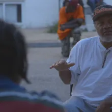 a few Black male Baltimore residents sit together in conversation