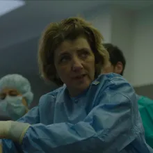 Caucasian women is dressed in blue and white gloves.