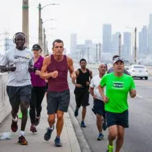 a group of men jog over a bridge in Downtown Los Angeles